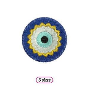 Puede incluir: Amuleto de ojo turco azul y amarillo con un centro blanco y azul claro. El amuleto es redondo y tiene un diseño decorativo.