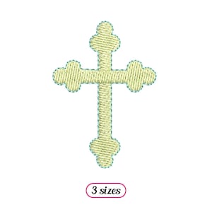 May include: A yellow embroidered cross with a simple design. The cross is outlined in teal.