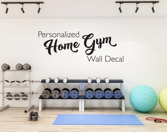 May include: A home gym with a wall decal that reads "Personalized Home Gym Wall Decal". The gym has a yoga mat, exercise balls, and weight racks with dumbbells.