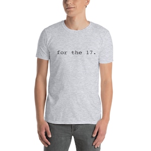 Peut inclure: Un t-shirt gris chiné avec le texte "for the 17." imprimé en noir.