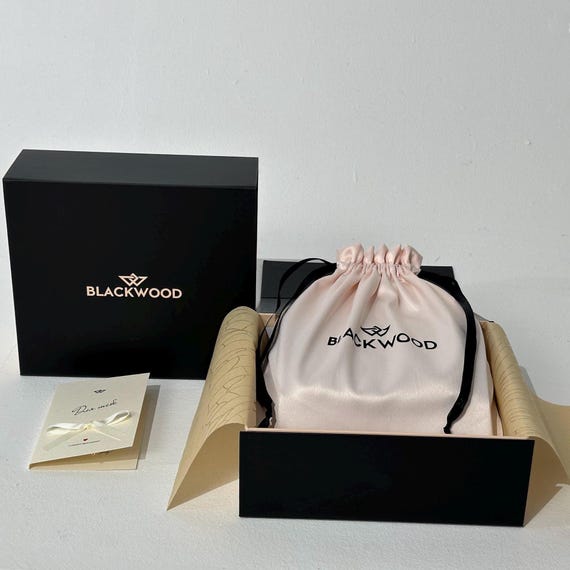 Borsa a mano in pelle di coccodrillo nera: petali di eucalipto e