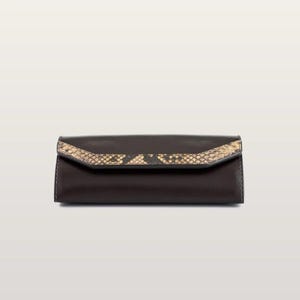 May include: A dark brown rectangular clutch with a smooth finish and a pointed flap closure. The flap features a textured, tan and black snakeskin-patterned inlay that runs horizontally across the center of the front panel.