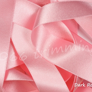 May include: A close-up of a pile of soft, pink satin ribbon. The ribbon is smooth and silky, with a subtle sheen. The color is a deep, rich pink, and the ribbon is perfect for crafting, decorating, or adding a touch of elegance to any project. The text "Dark Rose 401" is visible in the bottom right corner of the image.