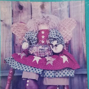 May include: Homespun Friends pattern for a 23-inch tall doll with a red, white, and blue dress and a basket. The pattern is called Starlite-Starbrite #130.