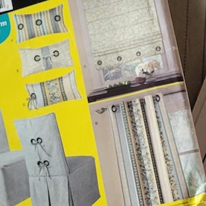 May include: A Simplicity sewing pattern for making window treatments, chair covers, and more. The pattern is for dummies and includes instructions for making a roman shade, a valance, and a chair cover. The pattern is in English and has a yellow and white background with a picture of a window, a chair, and a valance.