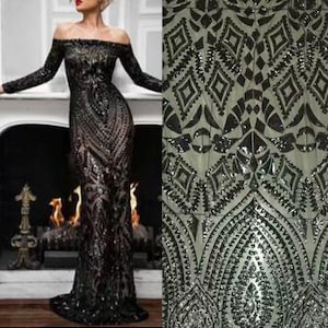 Op de afbeelding: Zwarte paillettenstof met een geometrisch patroon. De stof heeft een zilveren glans en is perfect voor avondkleding.