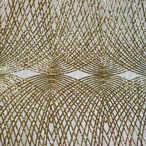 Op de afbeelding: Goudkleurige glitterstof met een geometrisch patroon van elkaar kruisende lijnen. De stof heeft een doorschijnende, gaasachtige textuur.