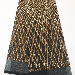 Op de afbeelding: Zwarte mesh stof met gouden pailletten in een geometrisch patroon.
