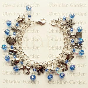 May include: A silver charm bracelet with blue crystal beads and various silver charms, including a globe, a snowflake, a horse, and a bird. The bracelet is on a white background with the text "Obsidian Garden" repeated.