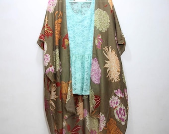 May include: A brown floral print kimono with a light blue lace top underneath. The kimono has a long, flowing silhouette and a wide, open neckline.