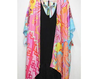 May include: A colorful floral print kimono with a pink, blue, and yellow color scheme. The kimono has a long, flowing silhouette and a wide, open neckline.