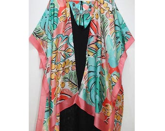 May include: A pink and blue floral print kimono with a white background. The kimono has a short sleeve and a wide, open neckline. The kimono is made of a lightweight fabric and is perfect for layering.