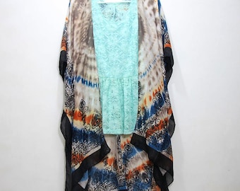 May include: A colorful patterned kimono with black trim. The kimono is made of a sheer fabric and has a tie closure. The kimono is worn over a light blue lace top.