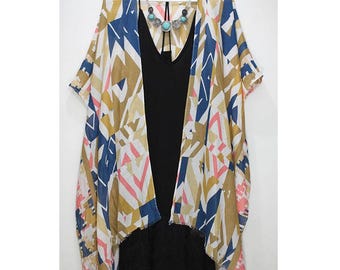 May include: A white, blue, and pink geometric patterned kimono with a black tank top underneath. The kimono has a short sleeve and a fringed hem.