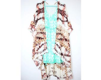 May include: A white, brown, and pink patterned kimono with a turquoise and white patterned dress underneath. The kimono has a short sleeve and is open in the front.