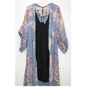 May include: A long, blue and pink floral patterned kimono with a black tank top underneath. The kimono has a tie closure at the neck and a paisley design.