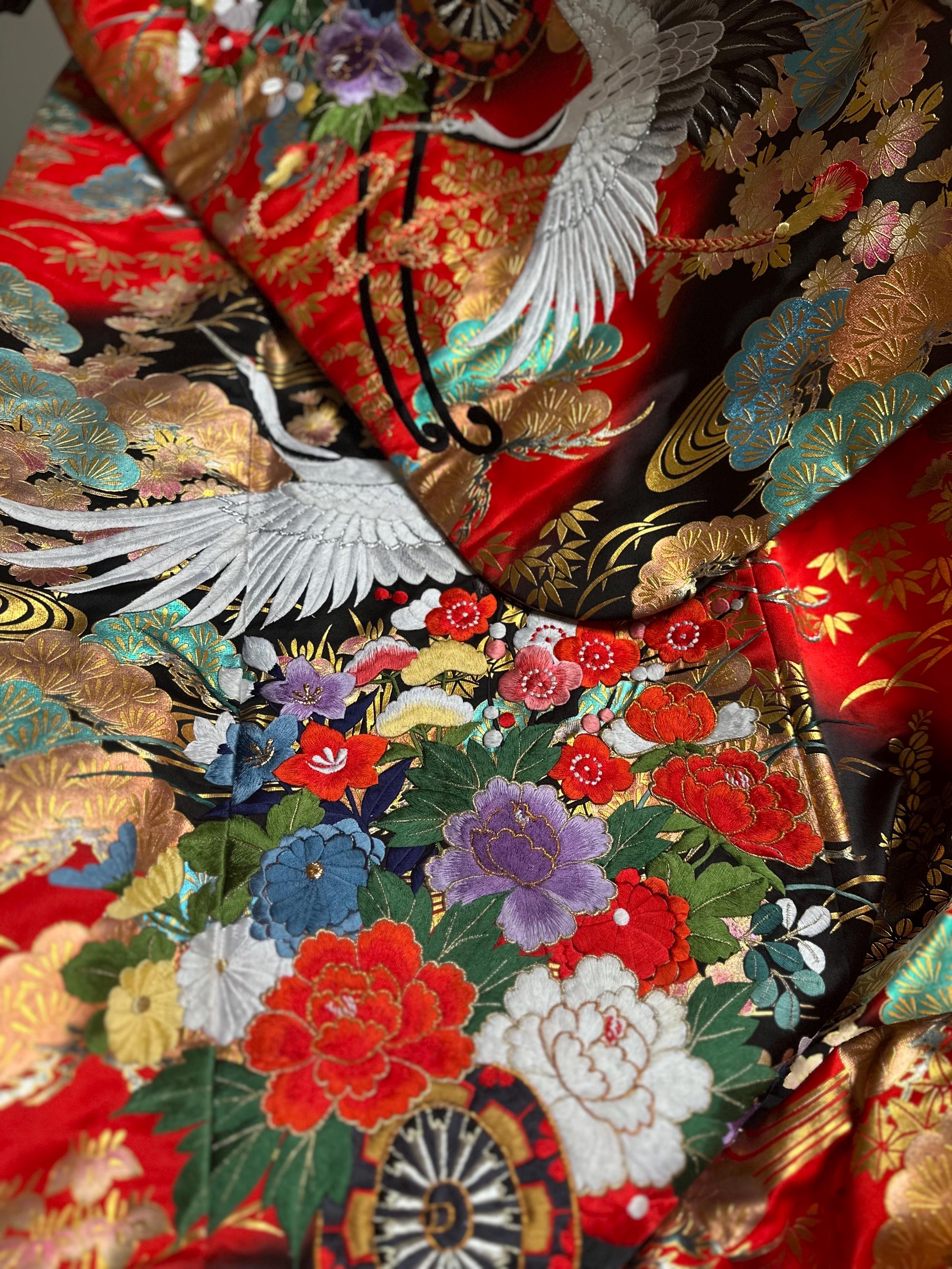 Detailed photograph of traditional Japanese uchikake wedding kimono with flying crane motifs showing intricate embroidery and court-inspired design elements