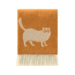 Puede incluir: Manta de color mostaza con una silueta de gato crema. La manta tiene un borde con flecos y está cuidadosamente doblada. El diseño del gato es simple y moderno, un elemento de decoración hogareña acogedor.