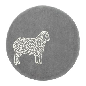 May include: A round, gray rug featuring a white sheep design. The sheep is depicted in a simple, dotted style, standing on the rug. The rug has a soft, textured appearance.