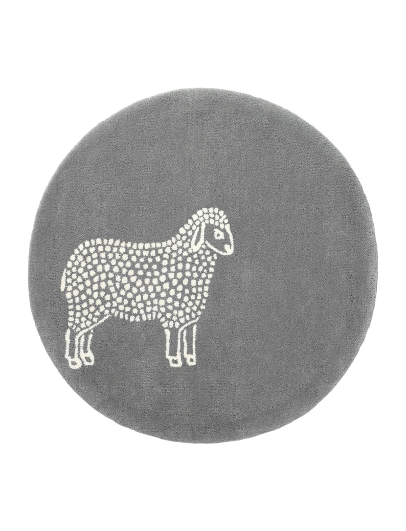 May include: A round, gray rug featuring a white sheep design. The sheep is depicted in a simple, dotted style, standing on the rug. The rug has a soft, textured appearance.