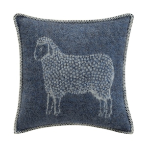 May include: A blue cushion with a white sheep design. The sheep is outlined in white and has a textured wool pattern.