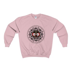 May include: Pink sweatshirt with a black and white mandala design featuring a black face with red eyes and a gold crown.