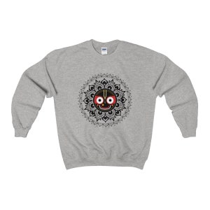 May include: A grey sweatshirt with a black and white mandala design featuring a black face with red eyes and a gold nose. The face is surrounded by a black and white mandala design.