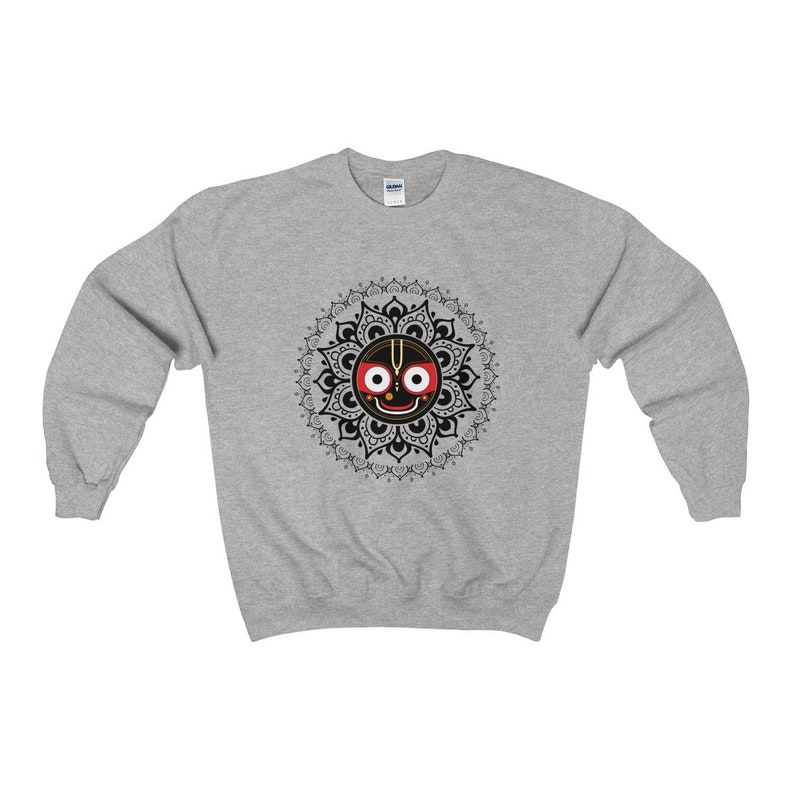 May include: A grey sweatshirt with a black and white mandala design featuring a black face with red eyes and a gold nose. The face is surrounded by a black and white mandala design.