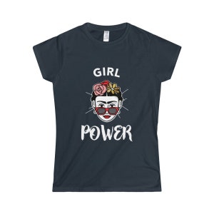 May include: A dark blue t-shirt with a white graphic of a woman with flowers in her hair and sunglasses. The text "GIRL POWER" is printed below the image.