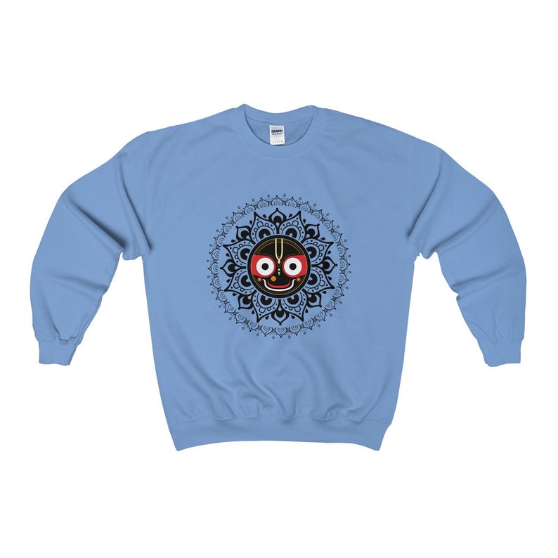 May include: A light blue sweatshirt featuring a black and gold mandala design with a black face, red eyes and a white dot on the forehead.