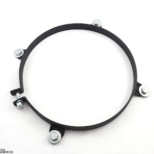 May include: A black metal ring with five silver screws. The ring is designed to hold a round object in place.