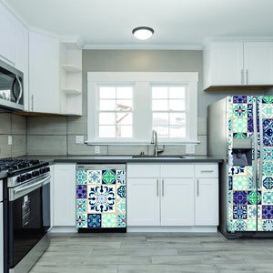 May include: A white kitchen with a stainless steel stove, microwave, and dishwasher. The refrigerator has a decorative tile design on the front.