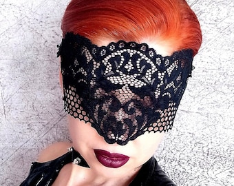 May include: A black lace eye mask with a delicate floral pattern. The mask covers the eyes and part of the forehead.