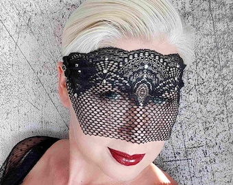 May include: A black lace eye mask with rhinestones. The mask is made of a delicate, sheer fabric and has a delicate floral pattern.