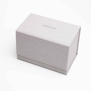 May include: A gray fabric box with the text 'estimo.co' printed on the top.