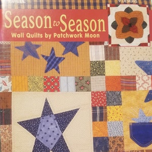 May include: A book cover titled "Season to Season" featuring a patchwork quilt design. The quilt has a large blue star, smaller blue stars, and various fabric squares in orange, yellow, and blue. The text "Wall Quilts by Patchwork Moon" is also visible.