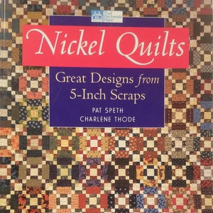 May include: A book cover titled "Nickel Quilts" with the subtitle "Great Designs from 5-Inch Scraps." The cover features a patchwork quilt design in various colors, including red, blue, brown, and yellow. The author's names are also visible.