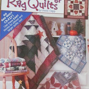 May include: A book cover titled "A Year of Rag Quilts" by Annis Clapp. The cover features several colorful rag quilts with star and geometric patterns. The book also includes instructions for pillows and larger quilts.