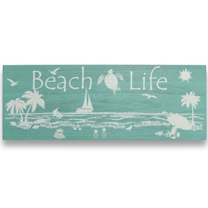 Pode incluir: Uma placa retangular de madeira com fundo turquesa e ilustrações brancas. A placa diz "Beach Life" e apresenta imagens de palmeiras, um veleiro e uma tartaruga. A placa foi projetada para evocar um tema de praia.