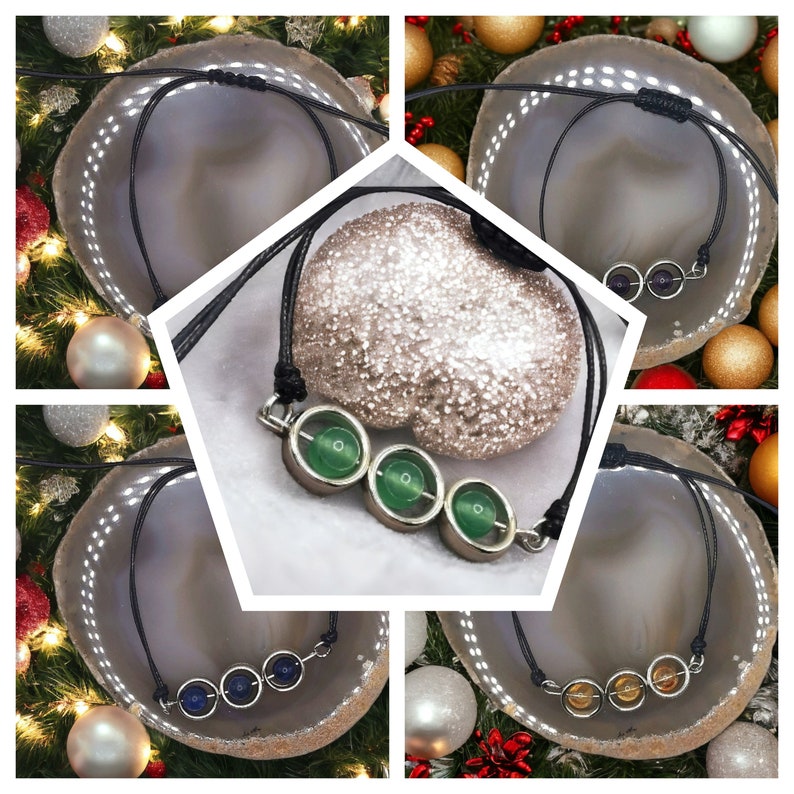 May include: Three necklaces with different colored stones. Each necklace has three stones in a row, with a silver setting. The stones are green, blue, and orange.