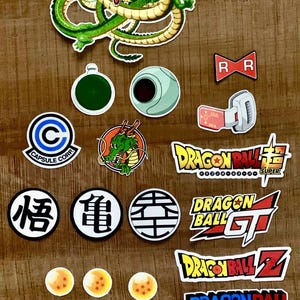 May include: A selection of Dragon Ball Z stickers, showcasing characters, logos, and symbols from the anime. Includes a green dragon, Capsule Corp logo, and various Dragon Balls.