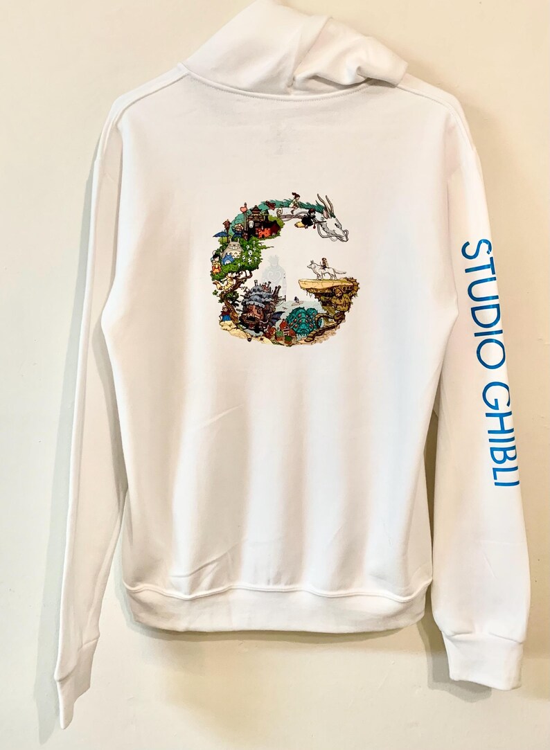 May include: White hoodie with a graphic of a G made up of Studio Ghibli characters and scenes. The right sleeve has the text "STUDIO GHIBLI" printed in blue.