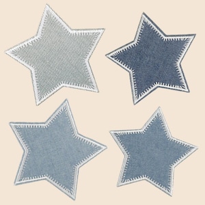 May include: Four star-shaped fabric patches in varying shades of blue and grey denim. Each patch features a distinct white stitched border along the edges, highlighting the five-pointed star silhouette with a textured, woven fabric appearance.