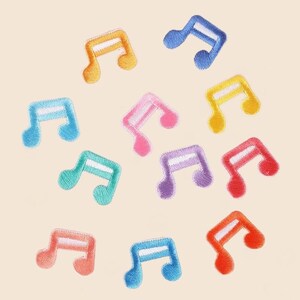 May include: A collection of eleven embroidered music note patches in various colours including orange, blue, yellow, pink, teal, purple, red, and peach. Each patch features a white horizontal bar across the centre of the musical note shape.