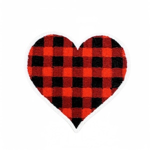 Può includere: Una toppa ricamata a forma di cuore con un motivo a quadri rossi e neri. La toppa presenta un bordo cucito bianco che delinea la forma del cuore, creando un netto contrasto con il tessuto rosso vivace e nero scuro del disegno.