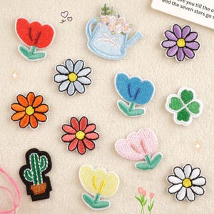 Puede incluir: Una colección de parches bordados termoadhesivos con varios diseños, incluyendo una regadera azul claro con flores rosas, un cactus verde en una maceta marrón, un trébol de cuatro hojas y varias flores coloridas como tulipanes y margaritas.