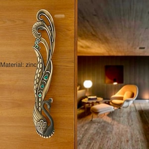May include: A decorative peacock-shaped door handle with green gem accents. The handle is made of zinc and has a vintage, ornate design. Material: zinc
