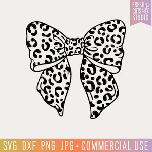 May include: Black and white leopard print bow with a large, rounded shape. The bow is a single piece with a center knot.