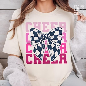 Könnte beinhalten: Weißes T-Shirt mit dem Wort "CHEER" in Rosa wiederholt und einer schwarz-weißen Karobinde.