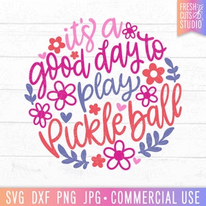 May include: It's a good day to play pickleball, a pink and purple design with flowers and hearts.